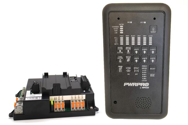 Power control module with orange terminal levers beside a tall wireless remote labeled PWRPR by WECO.